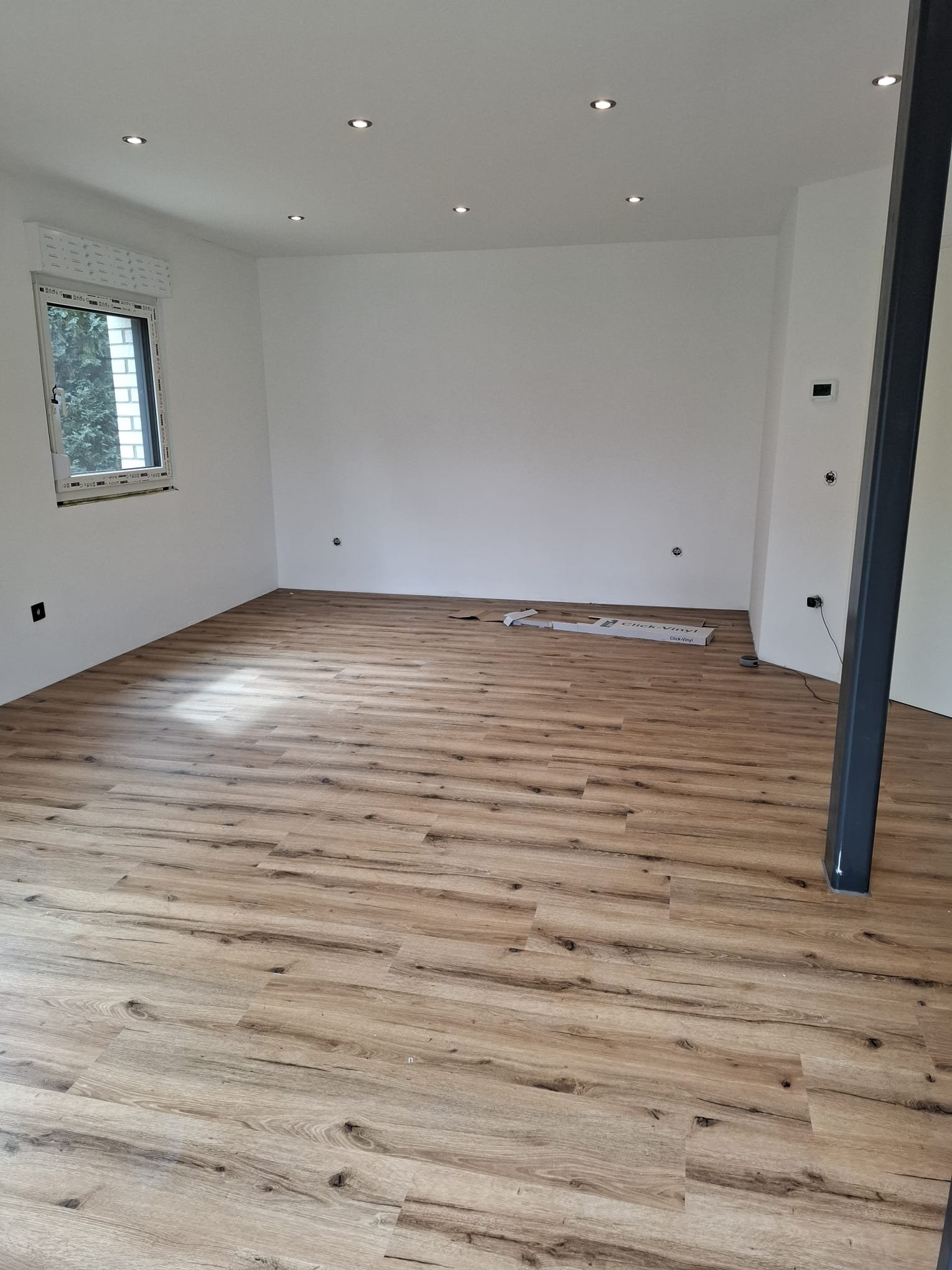 Fertiger Wohnraum mit Holzoptik-Boden und Stahlstütze
