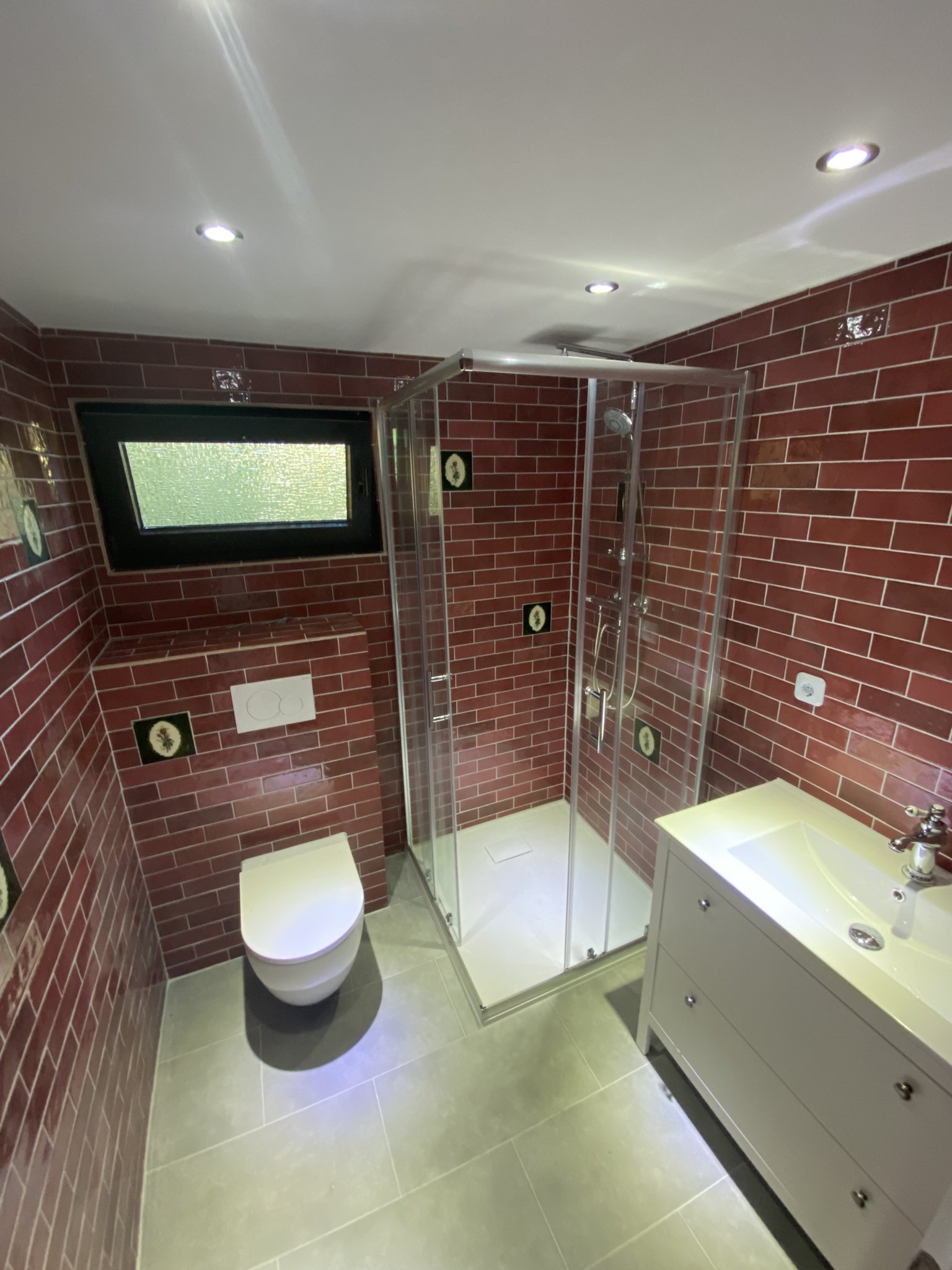 Bad mit roten Riemchenfliesen, Glasdusche und Wand-WC